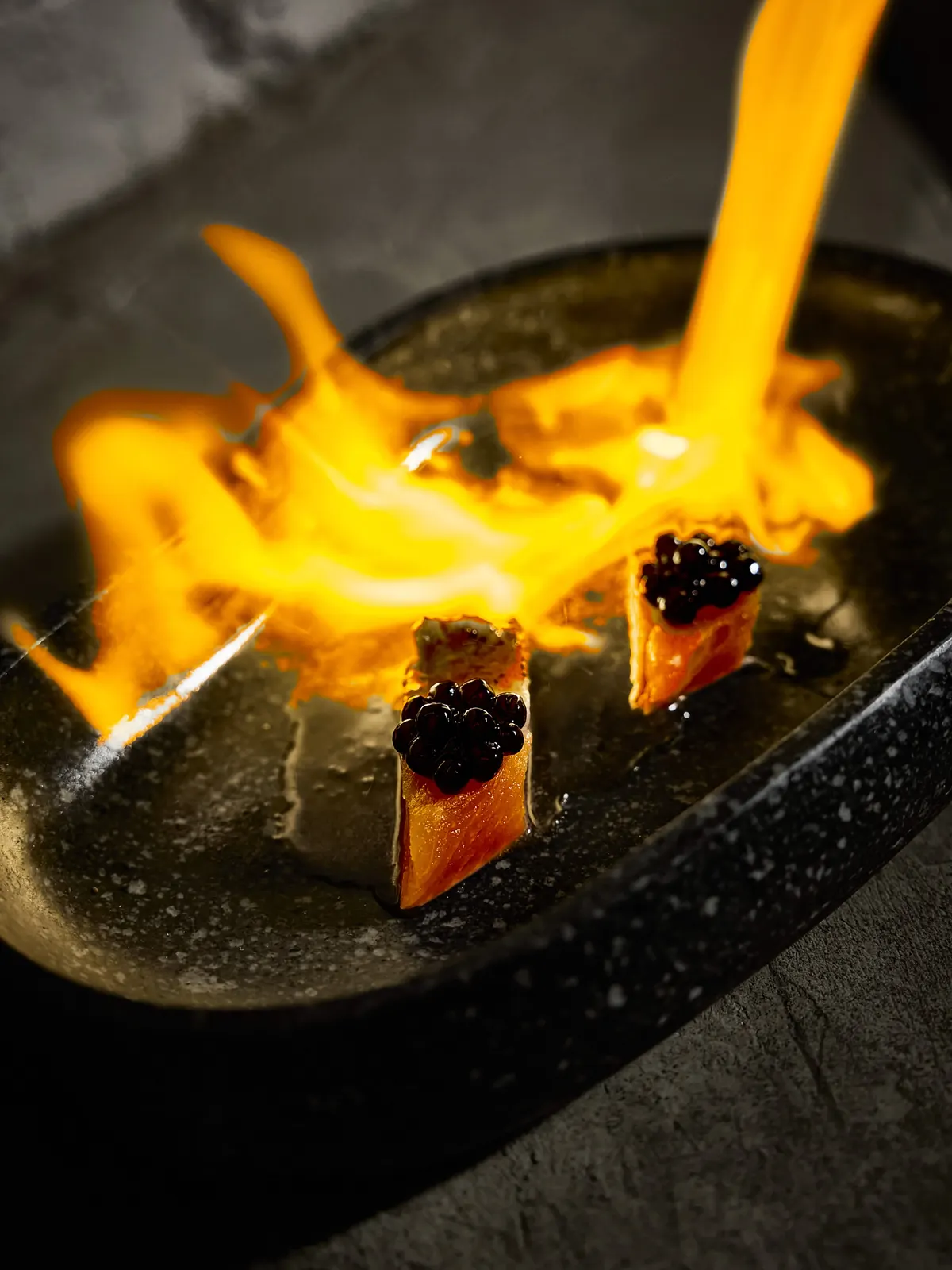 Pescado flameado en plato de piedra