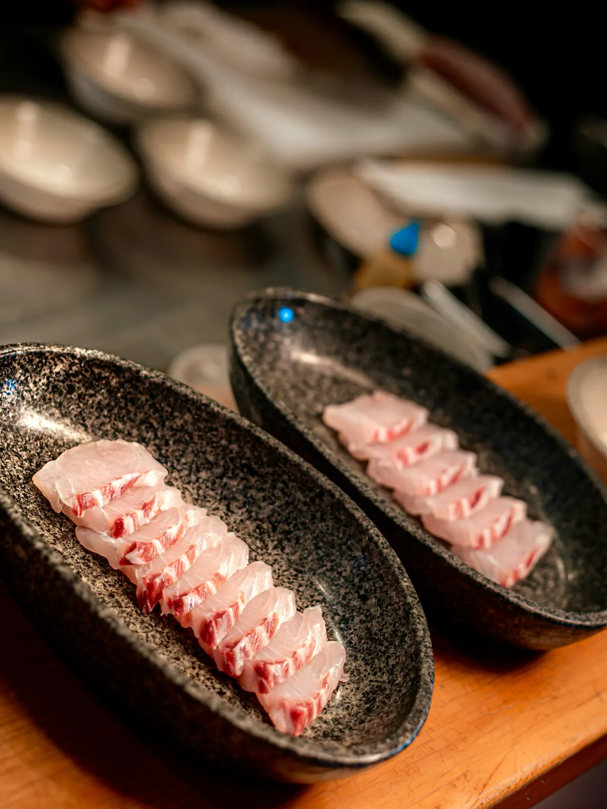Láminas de pescado blanco en platos de piedra